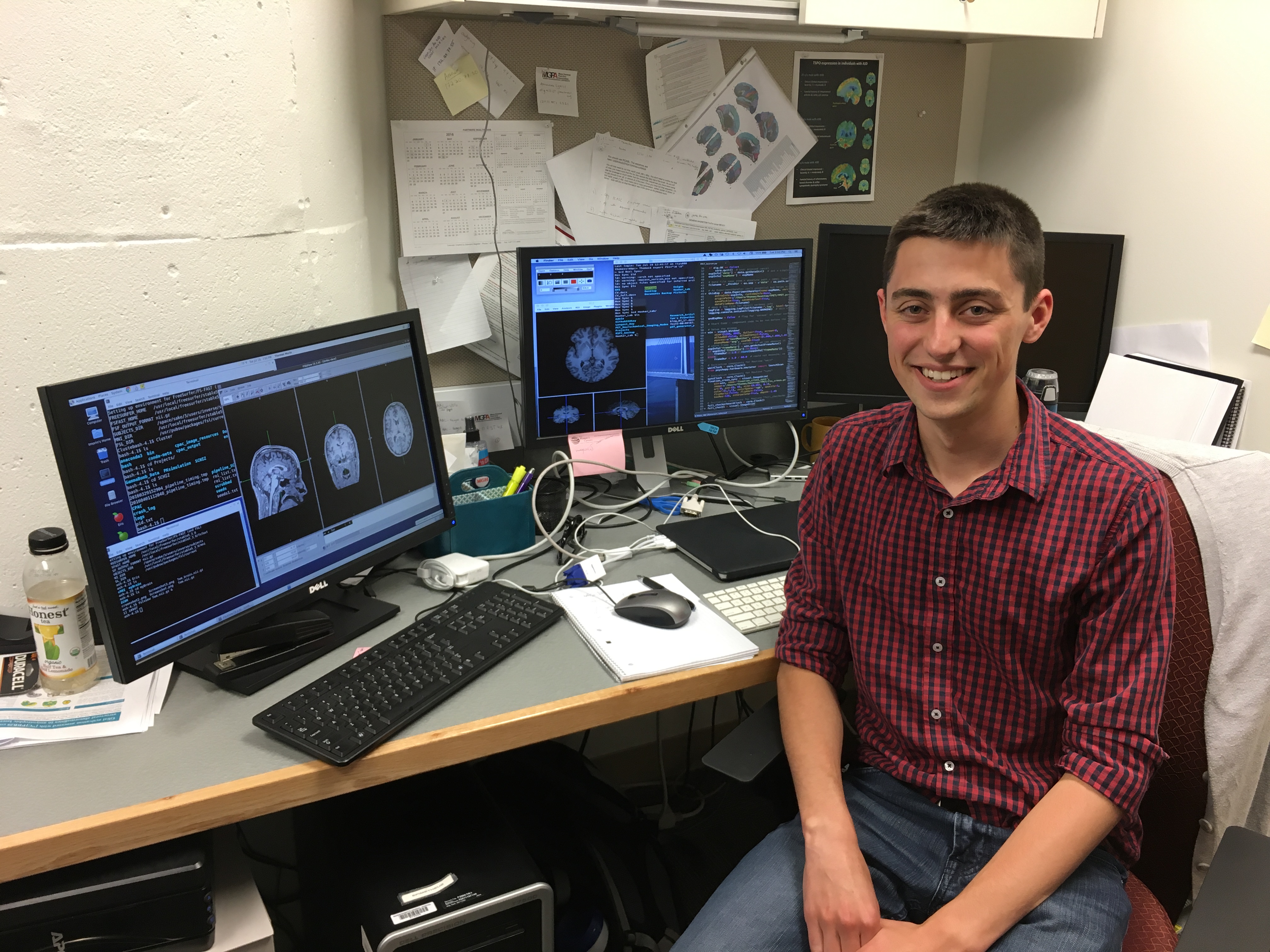 Me sitting in front of a computer in the lab I used to work at with some brain images opened up